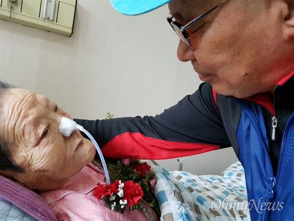 마산우리요양병원에 입원해 있는 일본군위안부 피해 김양주 할머니가 어버이날인 8일 카네이션 꽃을 받은 뒤 아들을 쳐다보고 있다.