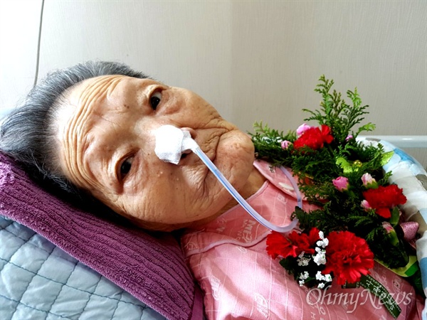 마산우리요양병원에 입원해 있는 일본군위안부 피해 김양주 할머니가 어버이날인 8일 카네이션 꽃을 받은 뒤 밝은 표정을 하고 있다.
