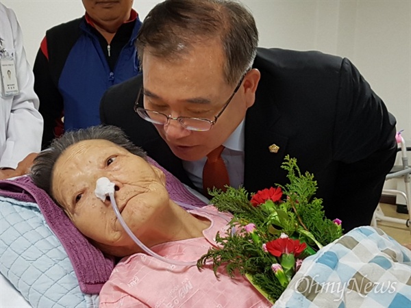 마산우리요양병원에 입원해 있는 일본군위안부 피해 김양주 할머니가 어버이날인 8일 카네이션 꽃을 받은 뒤 김종대 창원시의회 부의장이 귀에 대고 말하고 있다.