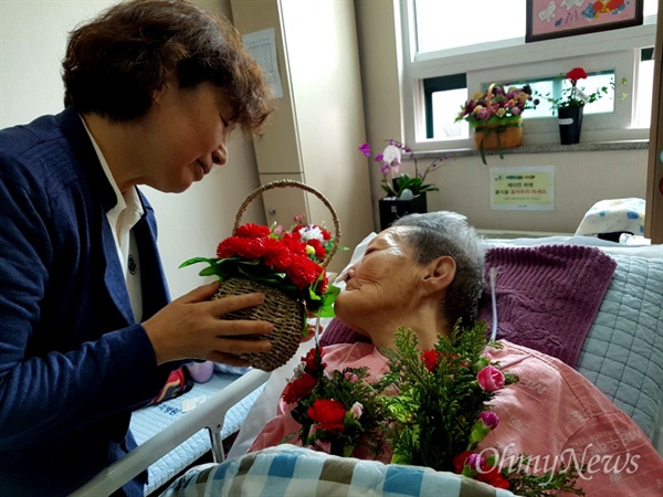마산우리요양병원에 입원해 있는 일본군위안부 피해 김양주 할머니가 어버이날인 8일 이경희 대표로부터 네이션 꽃을 받고 있다.