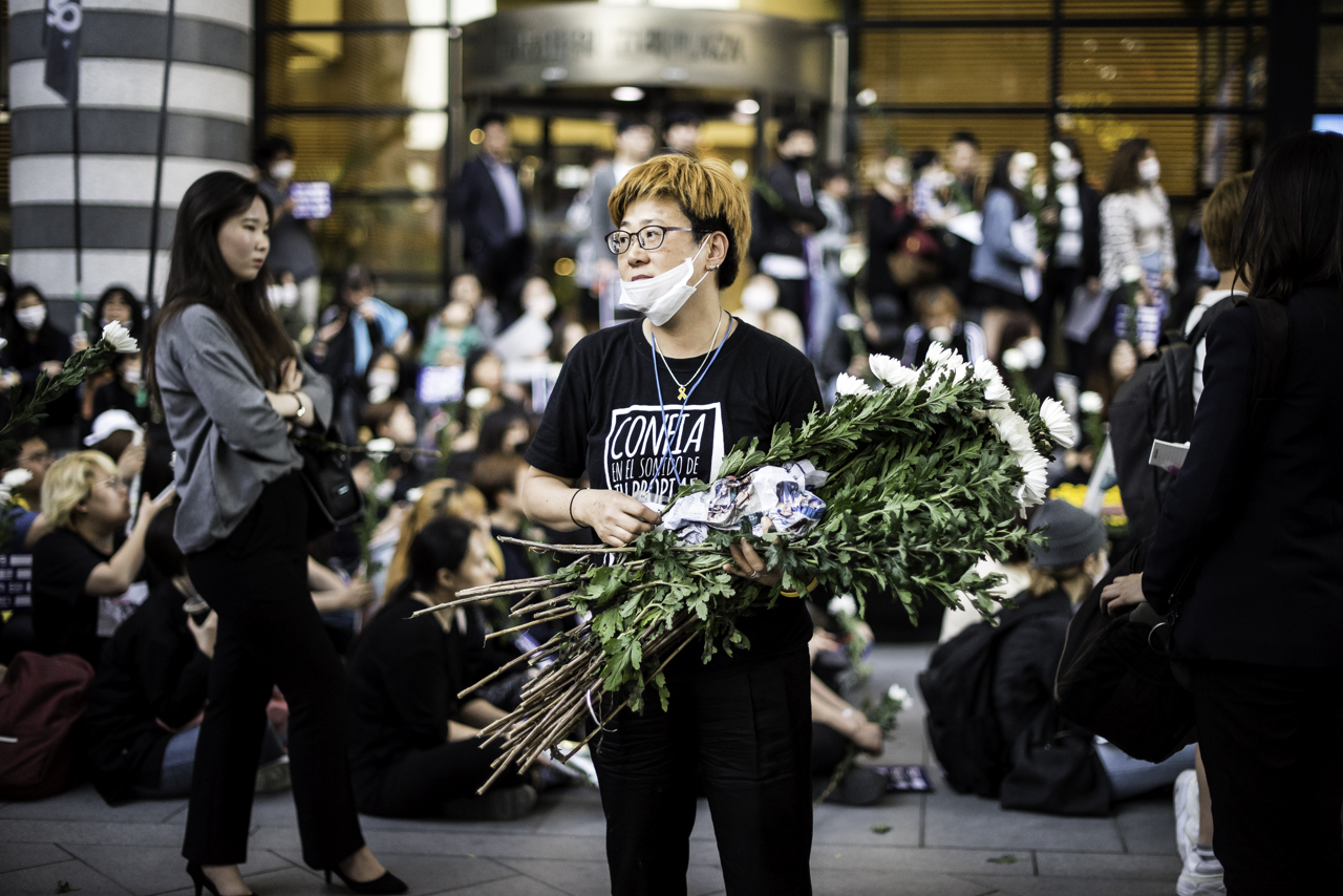 국화를 나눠 주고 있는 추모행진 스태프 5월 17일 강남역 10번출구 살인사건 1주기 추모행진 주최측이 참가자들에게 국화를 나눠주고 있다.