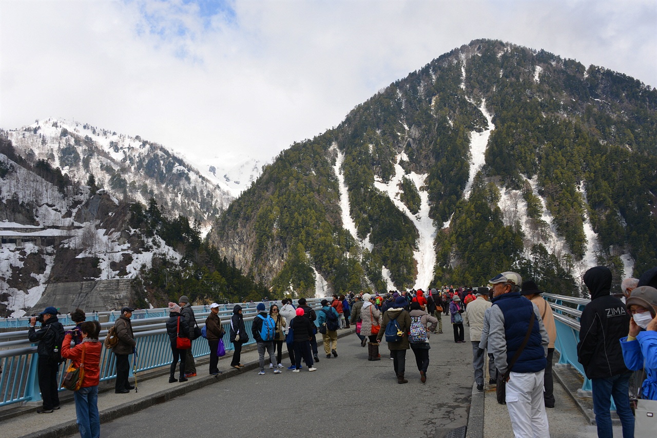관광객들이 구로베댐 정상을 걸으며 주변 경관을 구경하고 있다. 구로베댐은 해발 1470m에 건설된 일본 제일의 댐 높이(186m)를 자랑하는 아치식 댐이다.