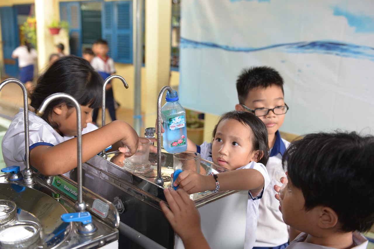 호치민 학생들이 마하연 승가회가 설치한 정수기에서 차가운 물을 병에 담아가고 있다.