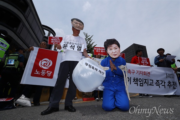  뇌물 등의 혐의로 박근혜 전 대통령이 첫 재판을 받는 23일 오후 서울 서초구 서울중앙지방법원 앞에서 노동당 당원들이 박근혜-최순실 부정축재재산 환수 촉구 기자회견을 열고 있다. 