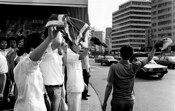 1987년 6월 10일 '6. 10 국민대회' 경적시위에 참여한 자동차를 향해 손을 흔들며 환호하는 시민들