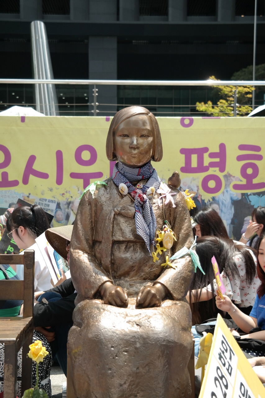 24일 오후 서울 종로구 중학동 옛 일본대사관 앞에서 열린 '제1284차 일본군 성노예제 문제 해결을 위한 정기수요시위' 참가자들이 소녀상을 에워싼 채 인도에 앉아 있다.