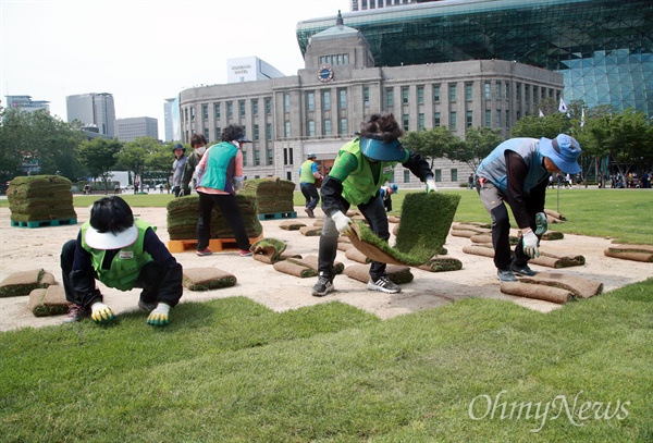 서울시 직원들이 30일 오후 서울광장에서 불법천막이 있던 자리에 잔디를 옮겨 심고 있다.