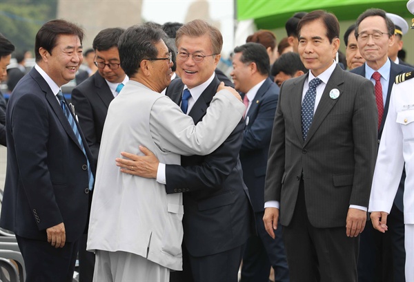 문재인 대통령이 31일 전북 군산시 새만금에서 열린 바다의 날 행사에 참석하며 참석자와 포옹하고 있다. 
