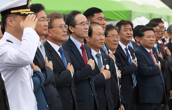 문재인 대통령(왼쪽 세번째)이 31일 전북 군산시 새만금에서 열린 바다의 날 행사에서 참석자들과 함께 국기에 대한 경례를 하고 있다.