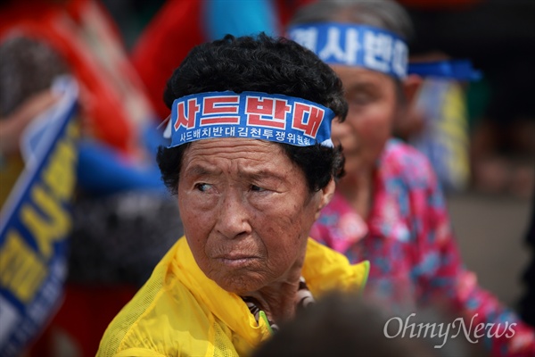 경계하는 주민들 사드반대 수요집회에 참석한 소성리 주민들이 대형차량이 지나가는 소리가 들리자 반사적으로 고개를 돌리고 있다. 집회장인 소성리 마을회관앞에는 사드 장비 추가 반입을 막기 위해 주민들이 설치한 바리케이드가 설치되어 있다. 주한미군은 주민들을 피해 헬기로 장비를 옮기고 있다.