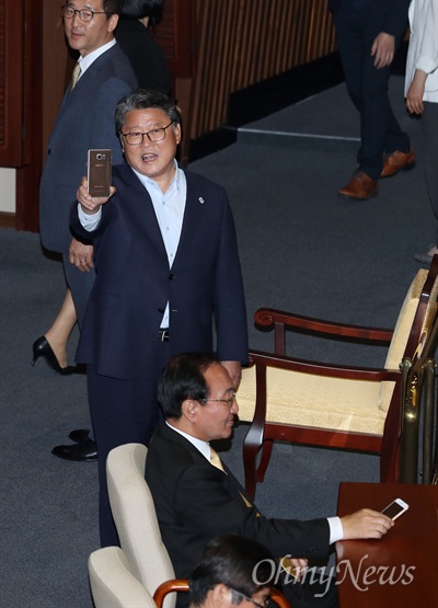 '기록'하겠다는 조원진, '맞불'놓은 노회찬 이낙연 국무총리 후보자에 대한 임명동의안을 처리하기 위해 31일 오후 열린 국회 본회의에 조원진 새누리당 의원이 불쑥 나타나, 삿대질에 고함을 치며 항의했다. 이 후보자 임명동의안 표결에 반대의 뜻을 분명히 한 조 의원은 "정권 바뀌자 마자 날치기 한다"며 표결에 참여한 의원들을 "나도 찍어줄게"라고 내뱉으며 촬영하기도 했다. 이를 곁에서 지켜 본 노회찬 정의당 원내대표가 책상 위에 놓여있던 스마트폰을 들고 있다. 