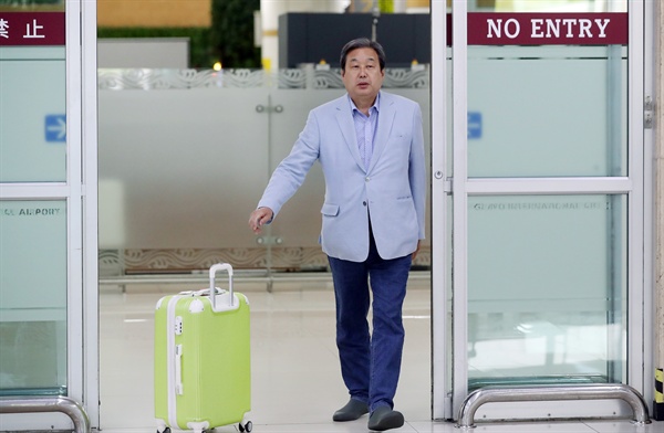 지난 5월 23일 오후 일본에서 귀국한 김무성 의원이 서울 김포공항 입국장에 도착하며 마중 나온 관계자에게 캐리어를 밀어 전달하고 있다.