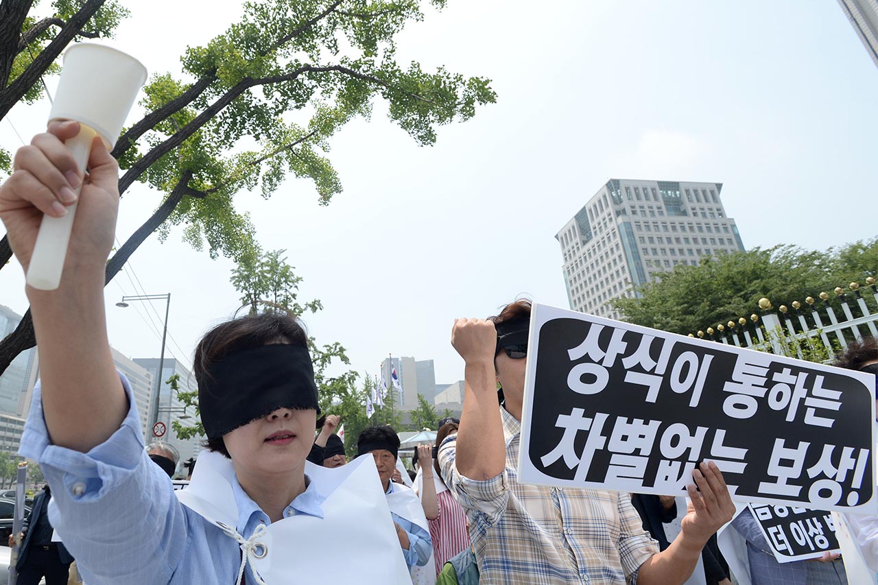 차별이 없는 보상을 '남북경협기업 생존권 보장을 위한 비상대책본부' 관계자들이 8일 오전 서울 종로구 정부서울청사 정문앞에서 "남북경협?금강산 기업의 차별없는 보상"을 요구하는 기자회견을 개최한후 '남북관계 개선'을 요구하며 정부서울청사에서 청와대까지 눈을 가린 채 행진을 벌이고 있다.