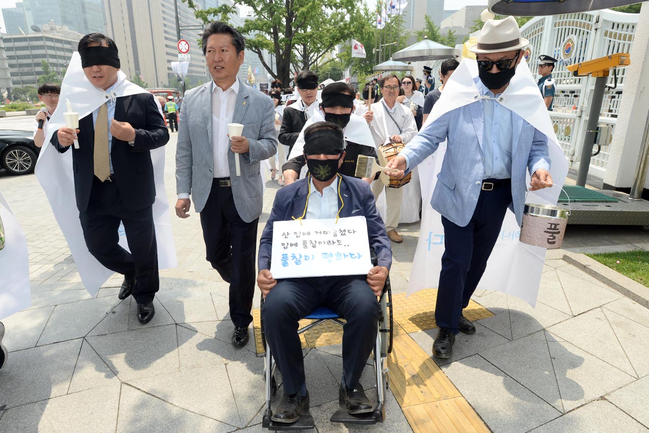 깜깜한 남북관계 개선을 촉구하며 '남북경협기업 생존권 보장을 위한 비상대책본부' 관계자들이 8일 오전 서울 종로구 정부서울청사 정문앞에서 "남북경협, 금강산 기업의 차별없는 보상"을 요구하는 기자회견을 개최한후 '남북관계 개선'을 요구하며 정부서울청사에서 청와대까지 눈을 가린 채 행진을 벌이고 있다.