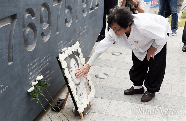  9일 오후 서울 서대문구 연세대학교 한열동산에서 열린 '제 30주기 이한열 열사 추도식'에서 참석자가 헌화를 마친 뒤 영정사진을 어루만지고 있다. 