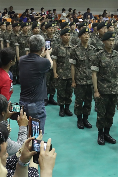지난 1일 경기도 연천군 수레울체육관에서 열린 육군 28사단 신병 수료식에서 6주간 신병 훈련을 마친 병사들의 가족들이 휴대전화로 사진을 찍고 있다