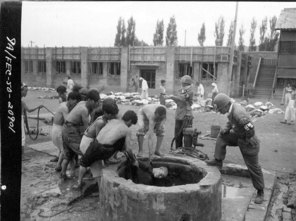  1950. 10. 10. 함흥. 학살 후 우물에 은폐시킨 시신을 주민들이 건져 올리고 있다.