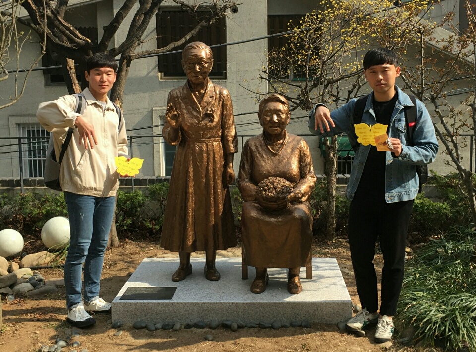  일본군 '위안부' 문제를 알리기 위해 미국을 자전거로 횡단할 예정인 대학생 2명이 '위안부' 동상 옆에서 포즈를 취하며 각오를 다지고 있다(왼쪽 조용주씨, 오른쪽 하주영씨).