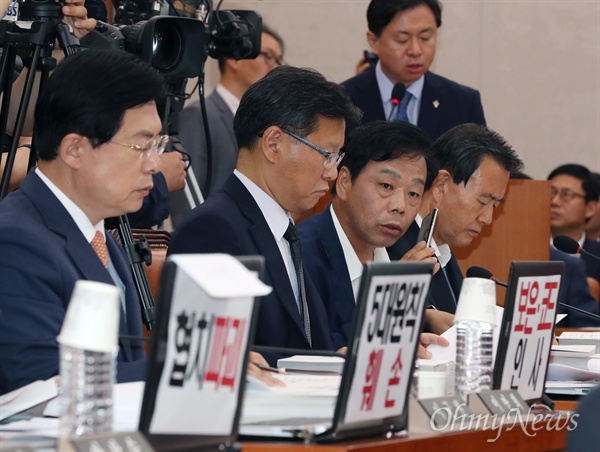 장내 피켓시위 중인 자유한국당 이완영 의원 김영춘 해양수산부 장관 후보자가 14일 오후 국회 농림축산식품해양수산위원회 회의실에서 열린 청문회에 나와 모두발언을 하고 있다. 오전 청문회에 불참했던 자유한국당 의원들은 오후 청문회장에 들어와 모니터에 '협치파괴' '5대원칙 훼손' '보은·코드 인사'라고 각각 적은 피켓을 내걸고 청문에 임했다. 김 후보자의 모두발언을 청취하던 이완영 자유한국당 의원이 어디선가 걸려온 전화를 받고 있다. 