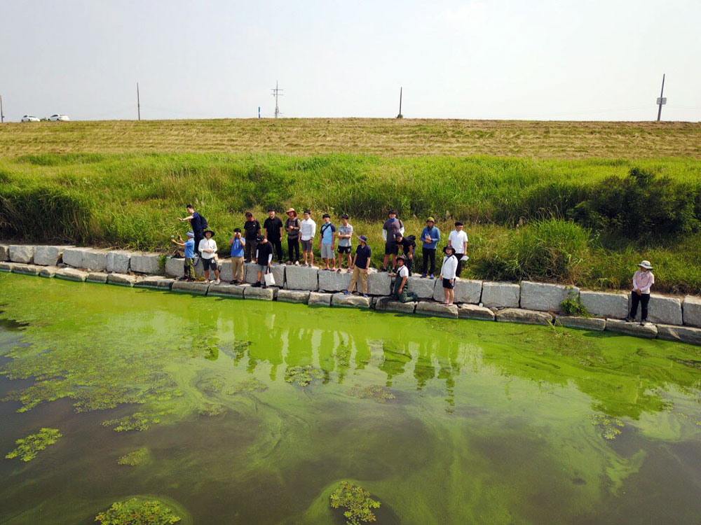 충남 논산시 금강에 창궐한 녹조밭에서 참석자들이 대화를 나누고 있다.