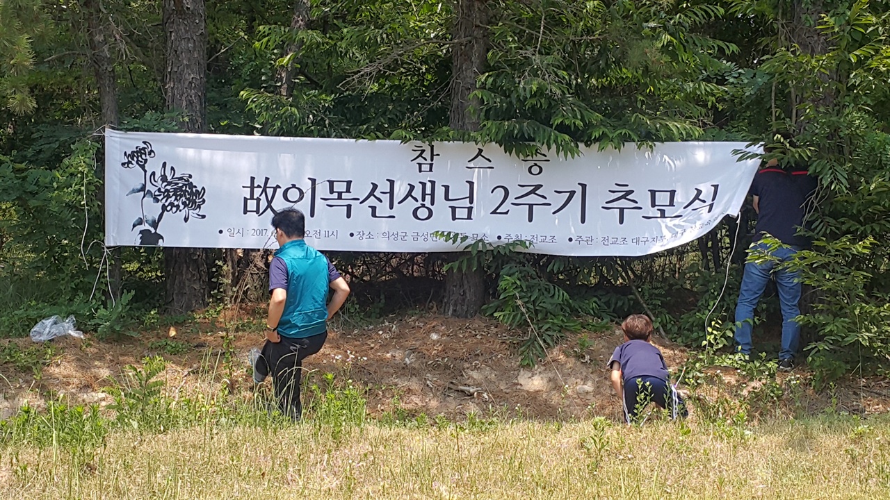 전교조 대구지부 교사들이 이목 선생 묘소 앞에서 플래카드를 걸고 있다.