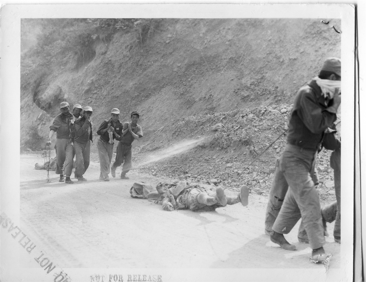  1951. 5. 24. 국군이 중국군 시신을 한데 모아 매장하고자 밧줄로 끌어 옮기고 있다.