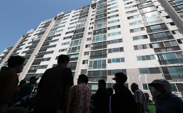 지난 15일 경남 양산시 한 아파트에서 외벽 작업자 밧줄을 잘라 살해한 사건 현장 검증을 벌이자 주민들이 안타깝게 지켜보고 있다.