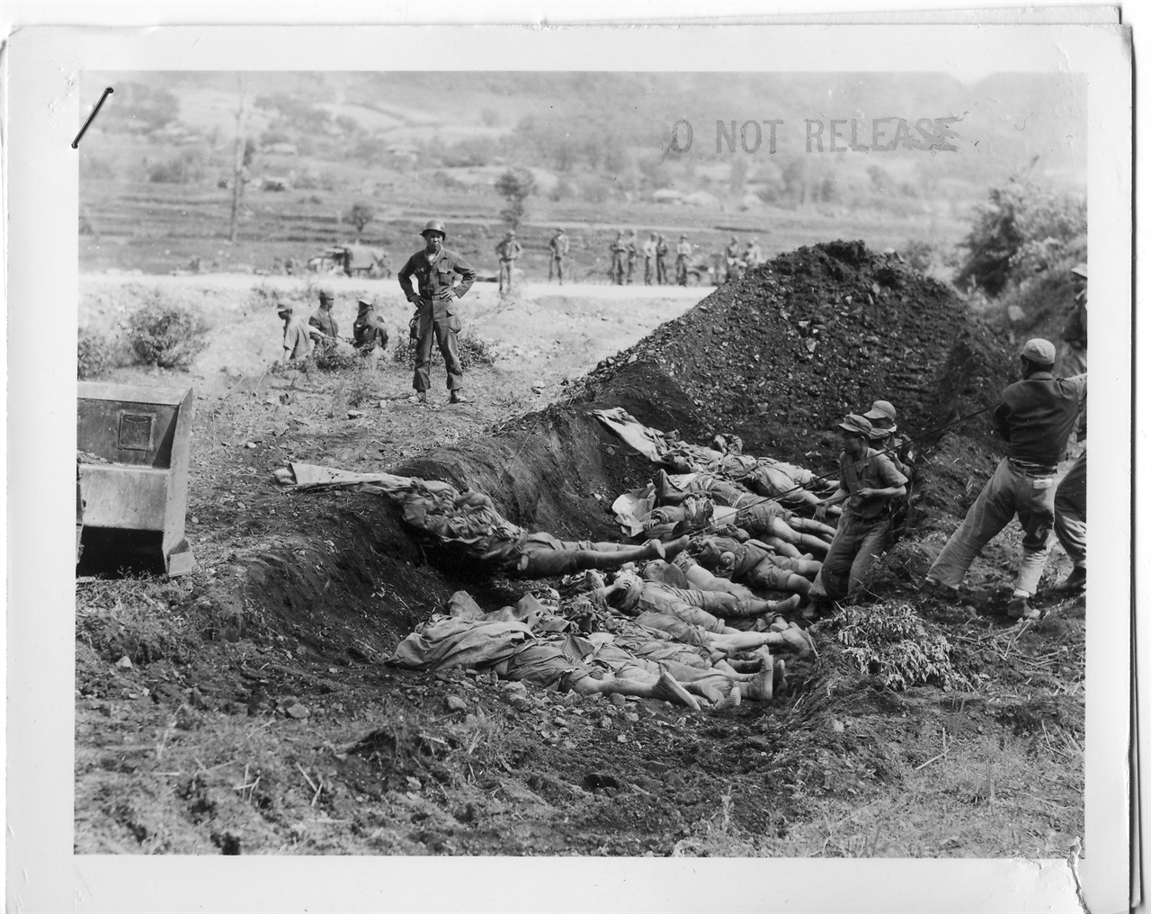  1951. 5. 17. 중부전선. 유엔군 병사들이 중국군 시신들을 매장하고자 구덩이로 모으고 있다. 