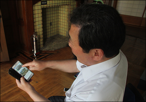 경교장의 과거와 오늘에 대해 손말틀(휴대폰) 사진을 보여주며 설명하는 김인수 대표