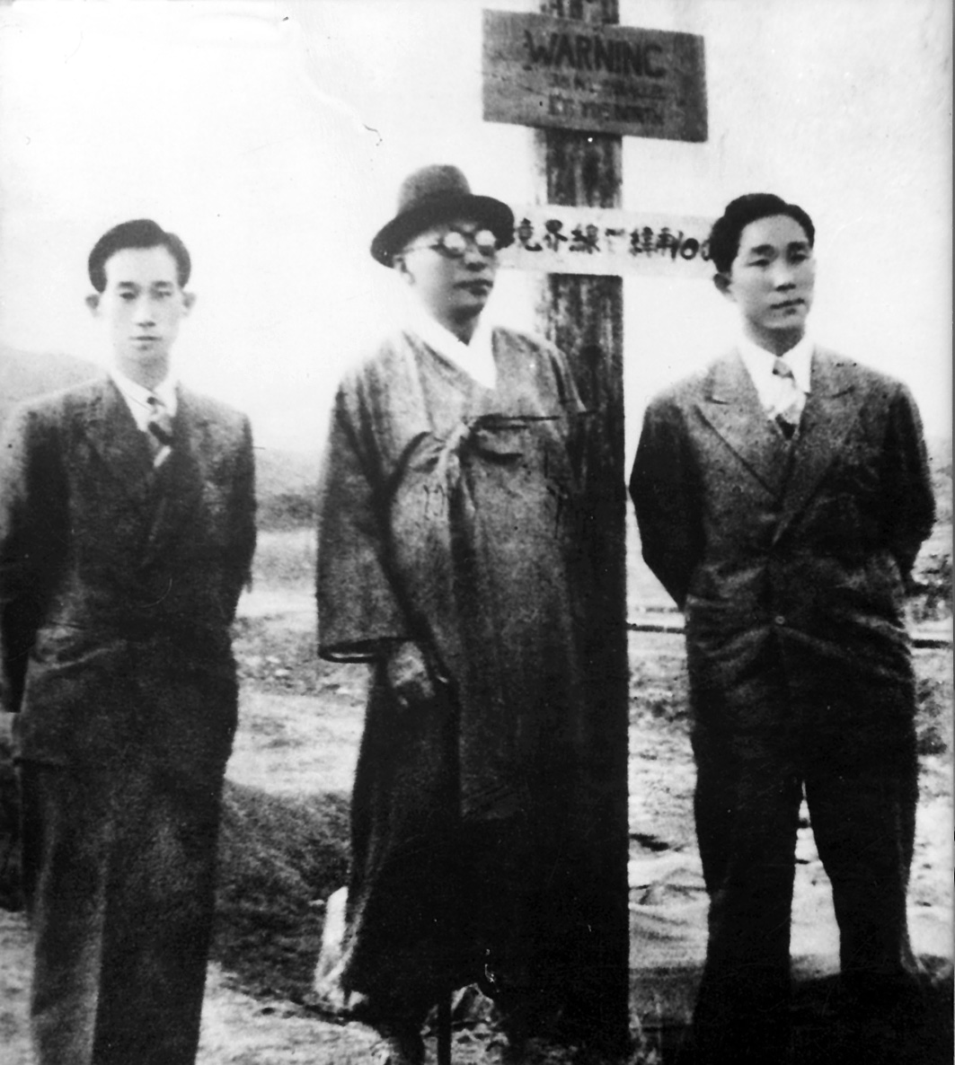  1948. 4. 19. 남북연석회의 차 평양으로 가는 길에 38선 표지 앞에선 백범(가운데, 왼쪽 선우진 비서, 오른쪽 아들 신)