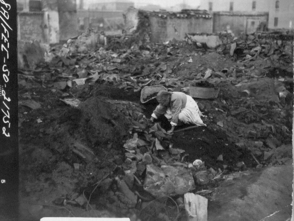  1950. 11. 16. 서울. 한 할머니가 폐허의 잿더미에서 땔감으로 석탄을 골라내고 있다. 