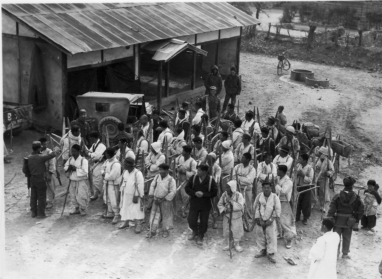  1951. 2. 4. 경찰이 지게에 군수물자를 지고 나르는 노무자들을 통제하고 있다. 
