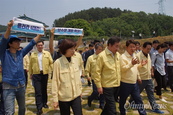  이낙연 국무총리가 21일 오전 낙동강 강정고령보를 찾아 녹조 발생 현황 등을 둘러보고 떠나자 환경단체들이 펼침막을 들고 뒤따르고 있다.