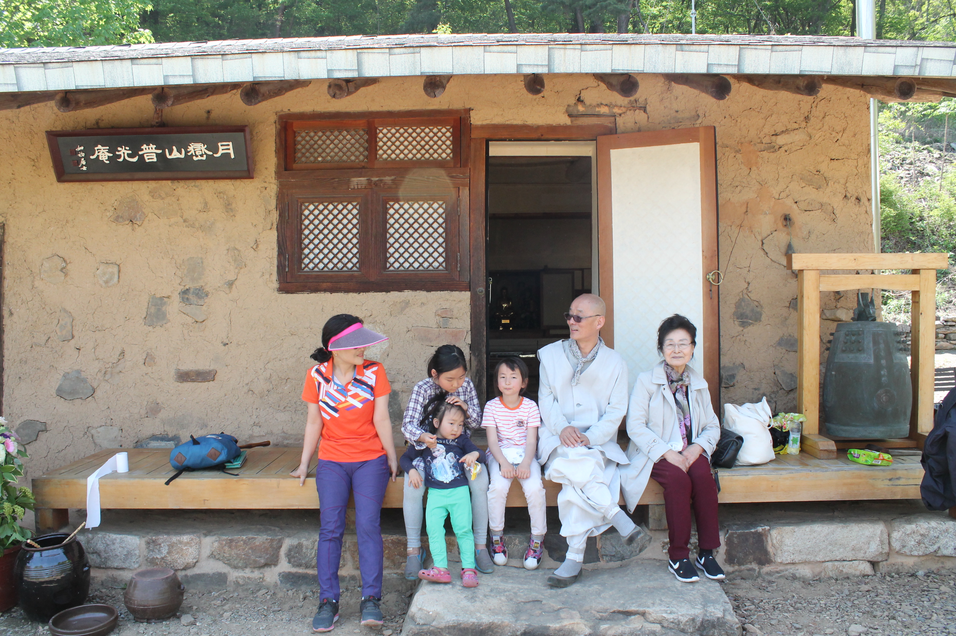 보광암 흙집 앞에서 아이들과 함께 앉아있는 명진 스님.