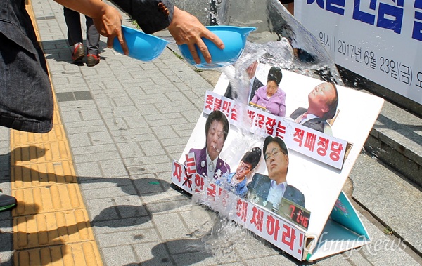 지역 시민단체들이 23일 오전 자유한국당 부산시당사를 찾아 "한국당이 촛불 개혁의 발목을 잡고 있다"고 비판하고 당 해체를 촉구했다. 이들은 한국당 의원들이 의정 활동는 잠을 자는 모습이 찍힌 사진에 물을 뿌리고 쓰레기봉투에 넣는 퍼포먼스도 진행했다. 