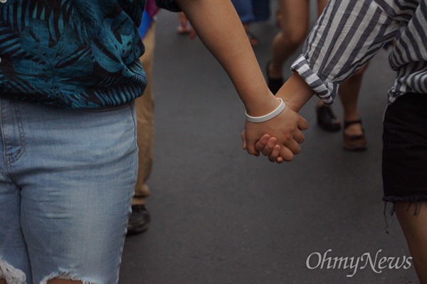 24일 오후 대구에서 열린 성소수자축제인 대구퀴어축제에 참가한 두 여성이 서로 손을 잡고 거리행진을 하고 있다.