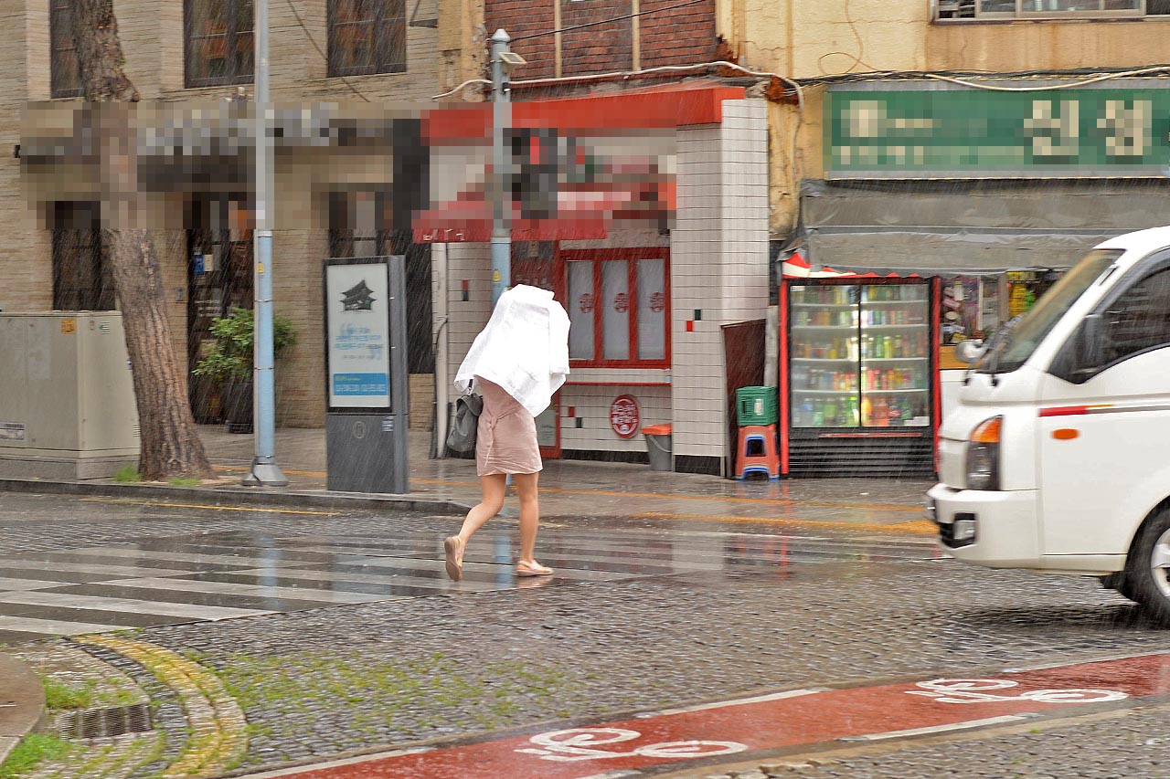 26일 오전 서우지역에 비가 내리고 있는 가운데 우산을 준비하지 못한 한 시민이 옷을 뒤집어 쓴채 발걸음을 재촉하고 있다.