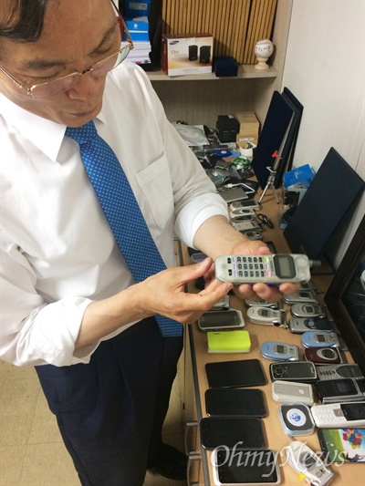 만 13년 넘게 대기업 LG와 특허분쟁을 벌이고 있는 김성수 서오텔레콤 대표가 지난 21일 자신의 사무실에 놓인 휴대전화를 들고 기능을 설명하고 있다. 