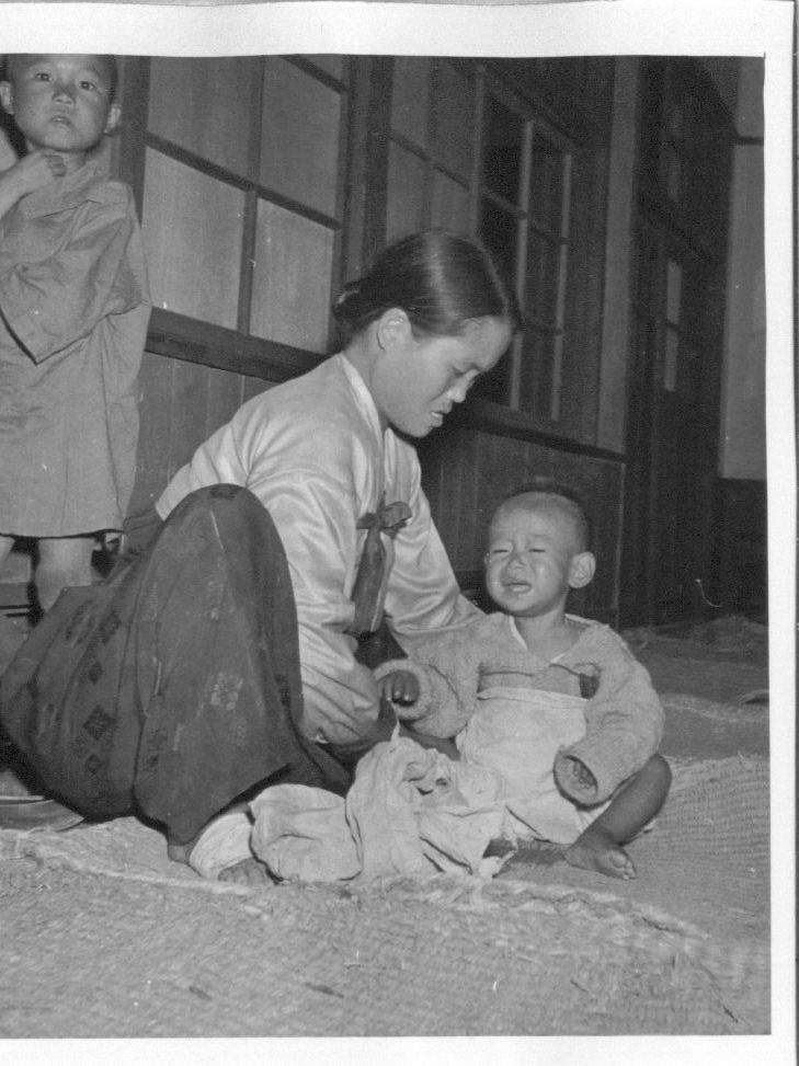  1950. 11. 3. 장소 미상. 고아원의 한 보모가 아이를 돌보고 있다.