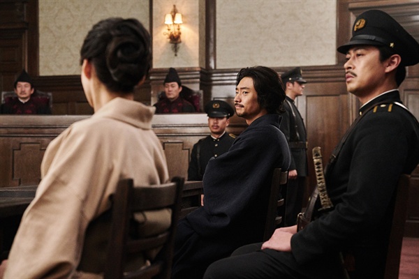 박열의 한 장면 재판정 의자에 앉은 박열이 연인 후미코를 바라보고 있다.
