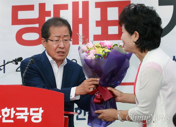 홍준표 자유한국당 신임 당대표가 3일 오후 서울 여의도 당사에서 열린 기자회견에 참석해 지지자로부터 당선 축하꽃다발을 선물받고 있다.