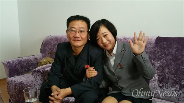남한의 어머니에게 손을 흔들어 보이는 탈북동포 김련희씨의 딸 련금양과 김련희씨 남편.