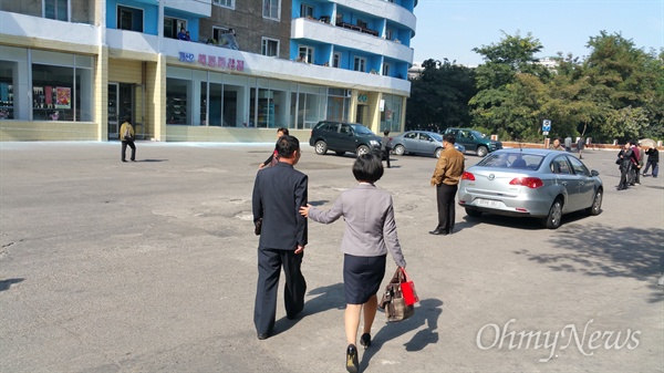 눈물을 글썽이며 버스정류장으로 걸어가는 아빠를 위로하는 탈북동포 김련희씨의 딸.
