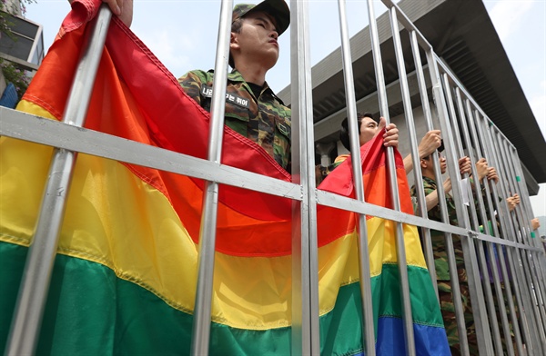 지난 7월 5일 오전 서울 종로구 세종문화회관 앞에서 성소수자 군인 처벌 중단을 촉구하는 성소수자들이 군복을 입고 감옥에 갇힌 퍼포먼스를 하고 있다.