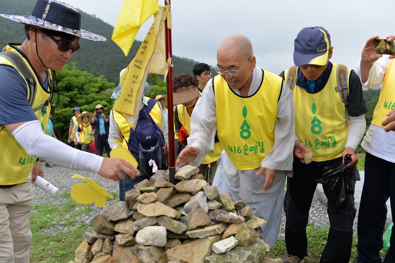 어울림마당이 끝난 후 오후 4시16분, 법륜 스님을 비롯한 참가자들이 전국 각지에서 가져온 돌로 기억의 숲에 돌탑을 쌓고있다.