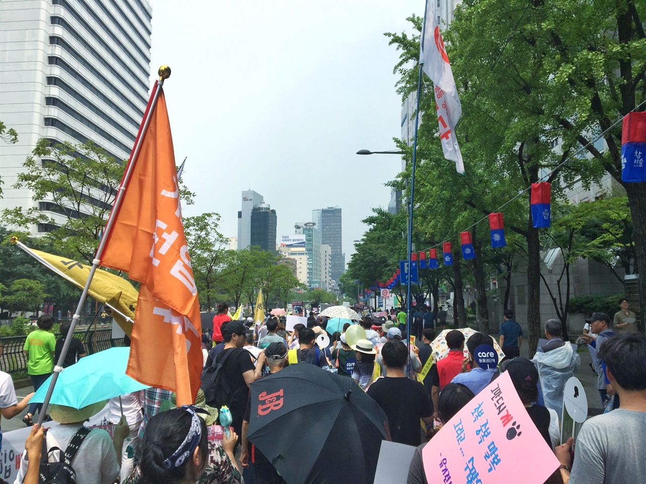  지난 7월 9일 진행한 '이제 그만 잡수시개' 행사의 참가자들이 각자의 슬로건을 들고 행진을 진행하고 있다. 오늘 우천때문에 잠시 연기되었던 거리 행진은 서울 광장에서 출발, 청계 광장, 광교 사거리, 을지로 입구를 지나쳐 돌아왔다.