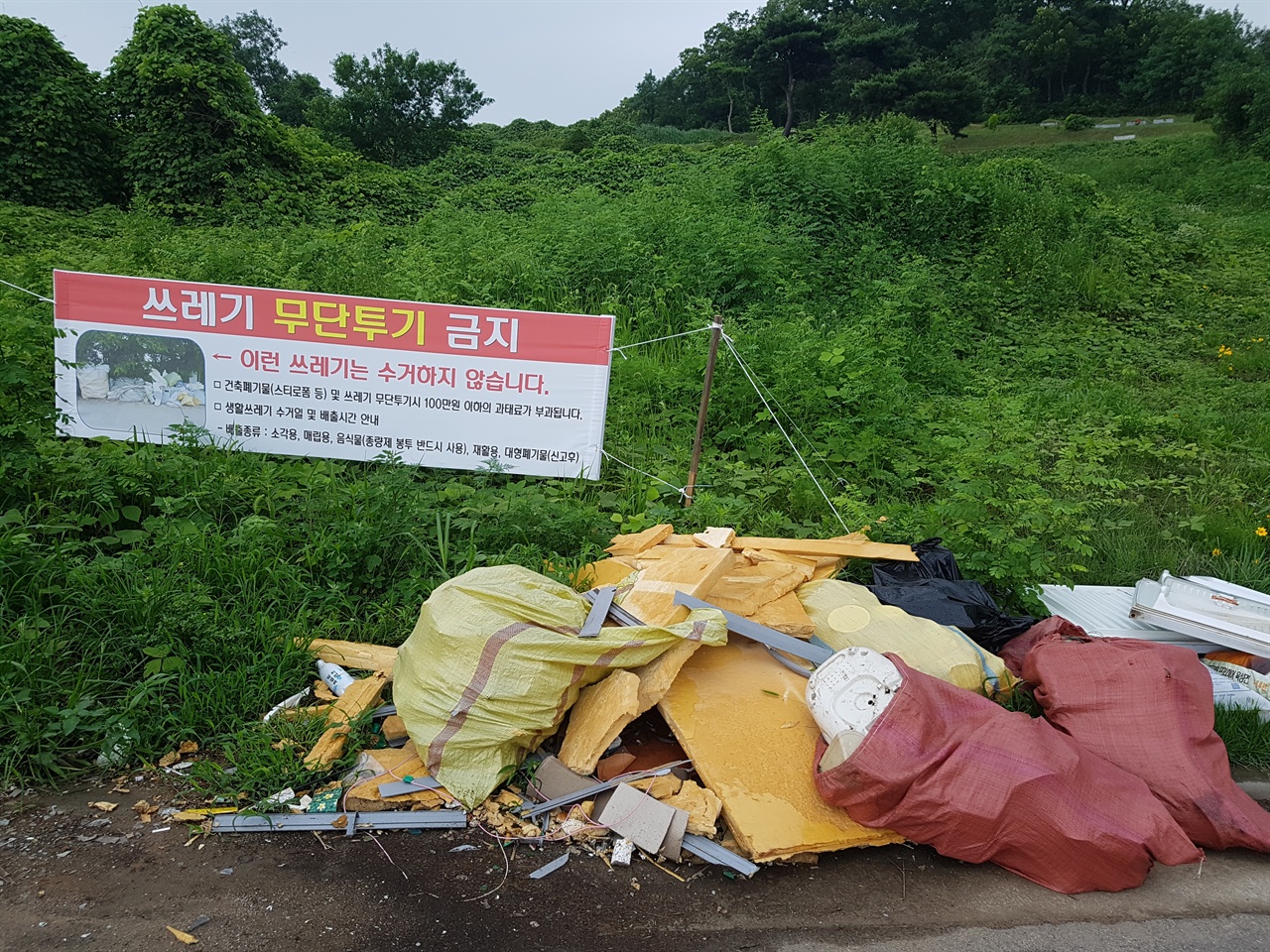 '쓰레기 무단투기 금지' 현수막이 걸렸습니다. 이에 아랑곳하지 않고 쓰레기를 무더기로 버렸습니다.