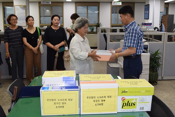 10일 오후 416안산시민연대 마이금 공동대표가 ‘4·16 정신을 계승한 도시비전 수립 및 실천에 관한 기본조례’ 제정을 위한 청구인 명부를 세월호 주무부서인 안산시 세월호수습지원단 담당자에게 전달하고 있다. 