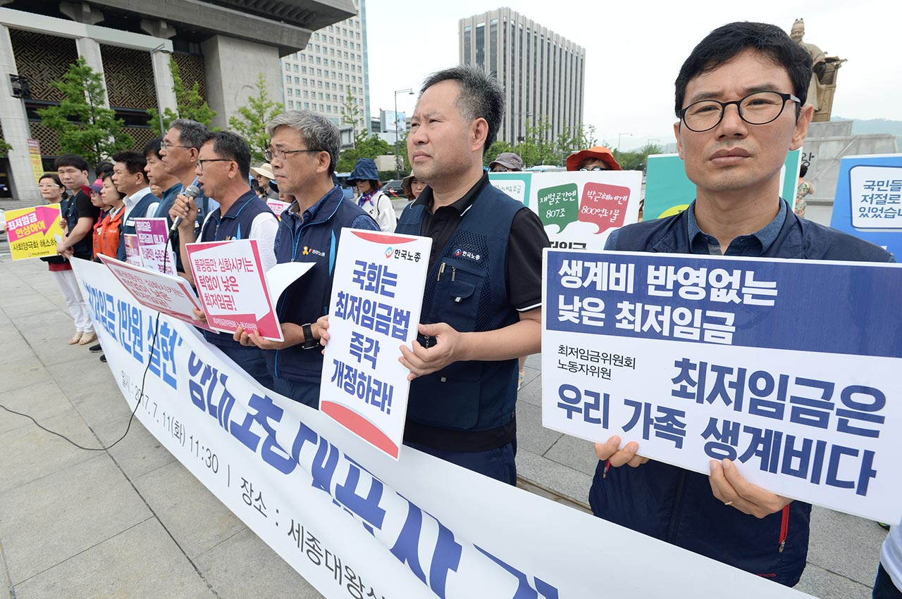 한국노동조합총연맹과 전국민주노동조합총연맹 관계자들이 11일 오전 서울 종로구 광화문광장에서 '최저임금 1만원 실현' 양대노총 대표자 기자회견을 열고 "최저임금 1만원 실현"을 요구하고 있다.