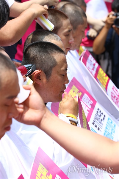  전국학교 비정규직 노동조합 조합원들이 12일 오후 서울 종로구 국가일자리위원회 앞에서 기자회견을 열고 스포츠강사 무기계약전환을 촉구 집단 삭발을 하고 있다. 